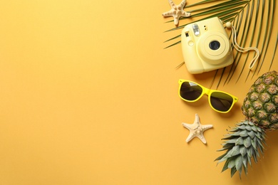 Photo of Flat lay composition with sunglasses and camera on color background, space for text. Beach accessories