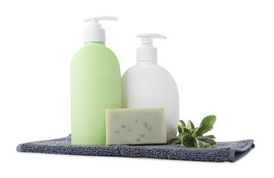 Photo of Soap bar, bottle dispensers and terry towel on white background