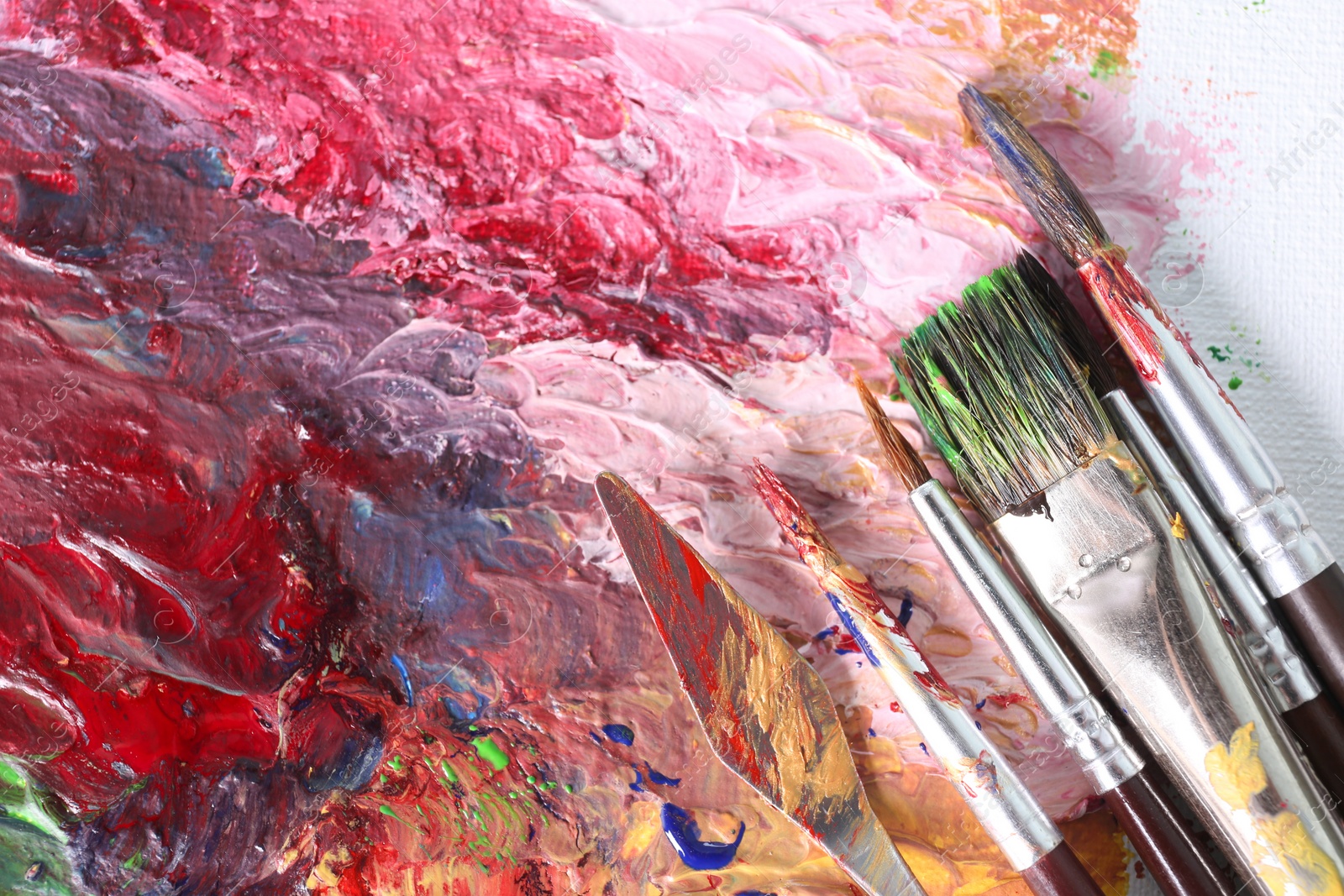 Photo of Abstract colorful artwork and brushes, closeup view