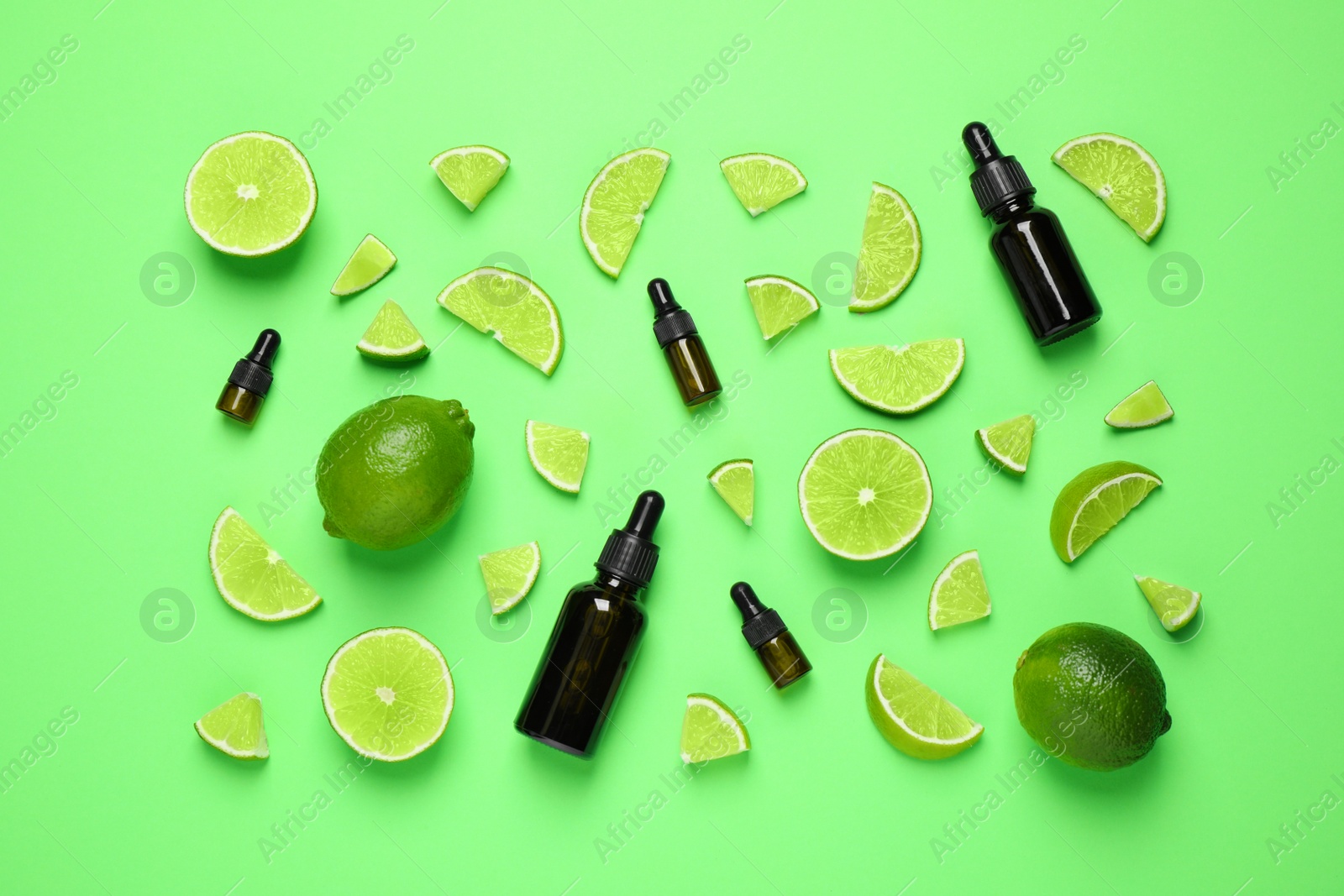 Photo of Flat lay composition with lime essential oil on green background