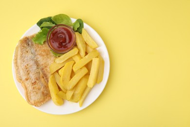 Photo of Delicious fish and chips with ketchup, spinach and lettuce on yellow table, top view. Space for text