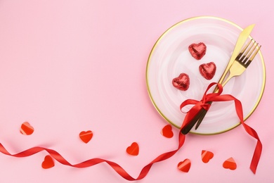 Photo of Beautiful table setting on pink background, flat lay with space for text. Valentine's Day dinner