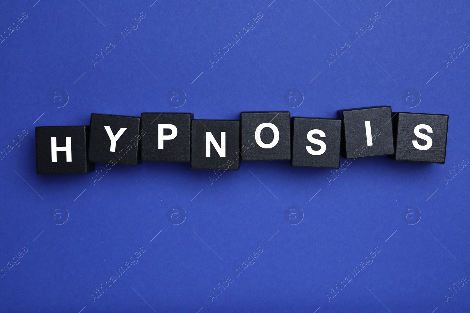 Photo of Black wooden blocks with word HYPNOSIS on blue background, flat lay