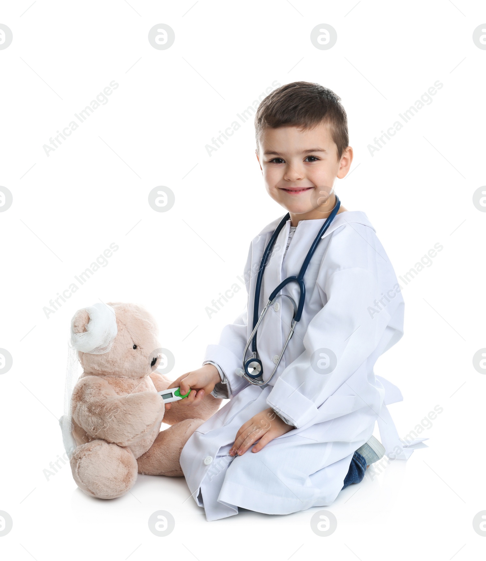 Photo of Cute child playing doctor with stuffed toy on white background