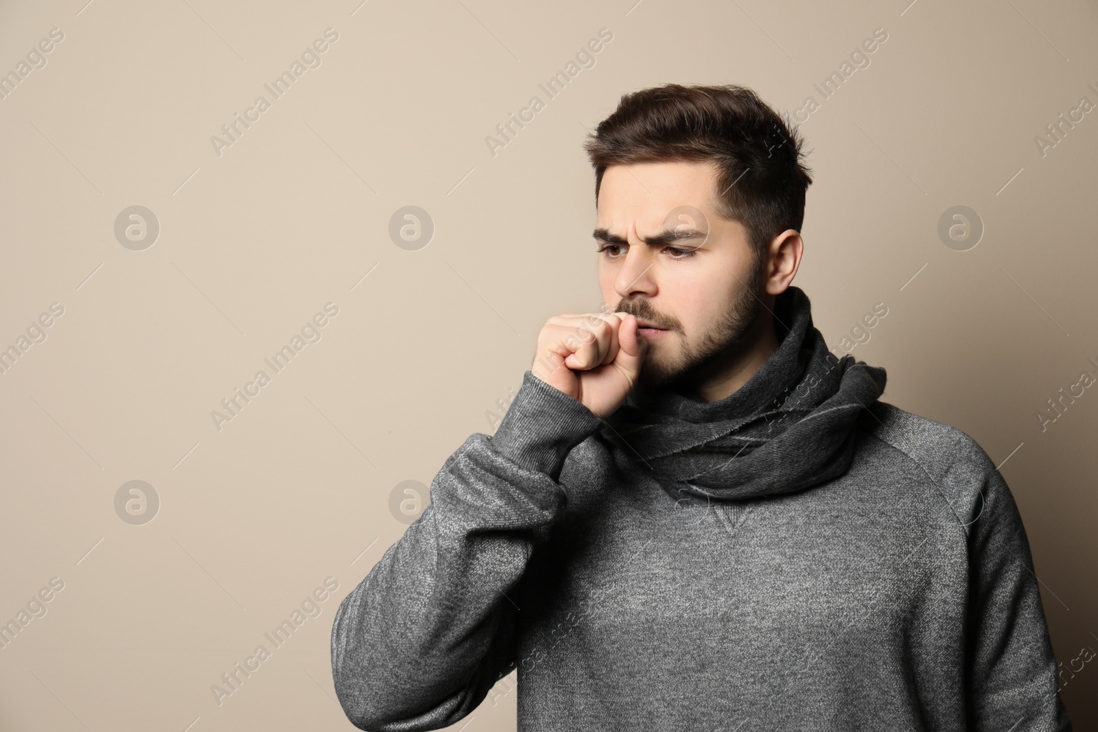 Photo of Handsome young man coughing against color background. Space for text