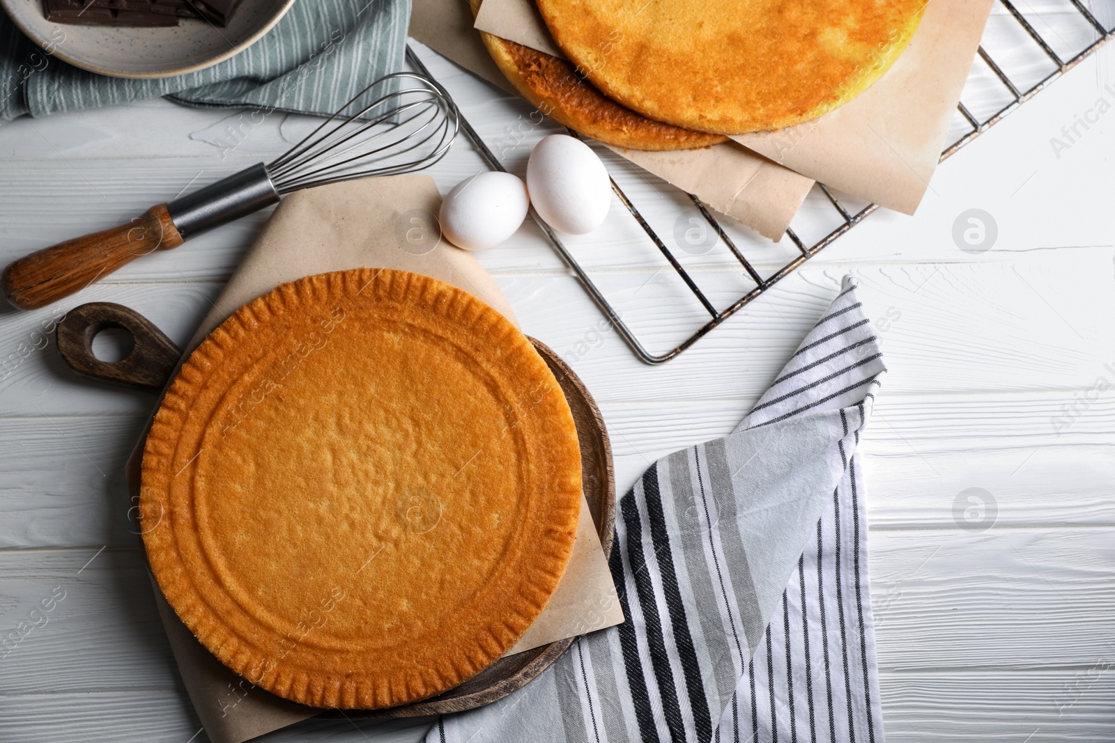 Photo of Ingredients for delicious homemade layer cake preparing on white wooden table, flat lay