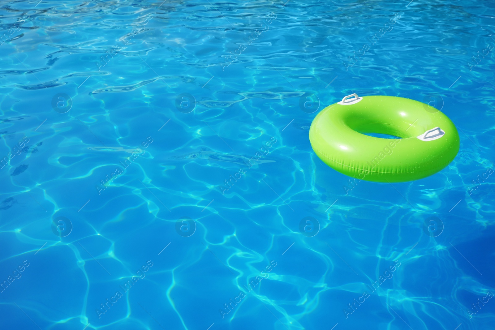 Photo of Inflatable ring floating in swimming pool on sunny day. Space for text