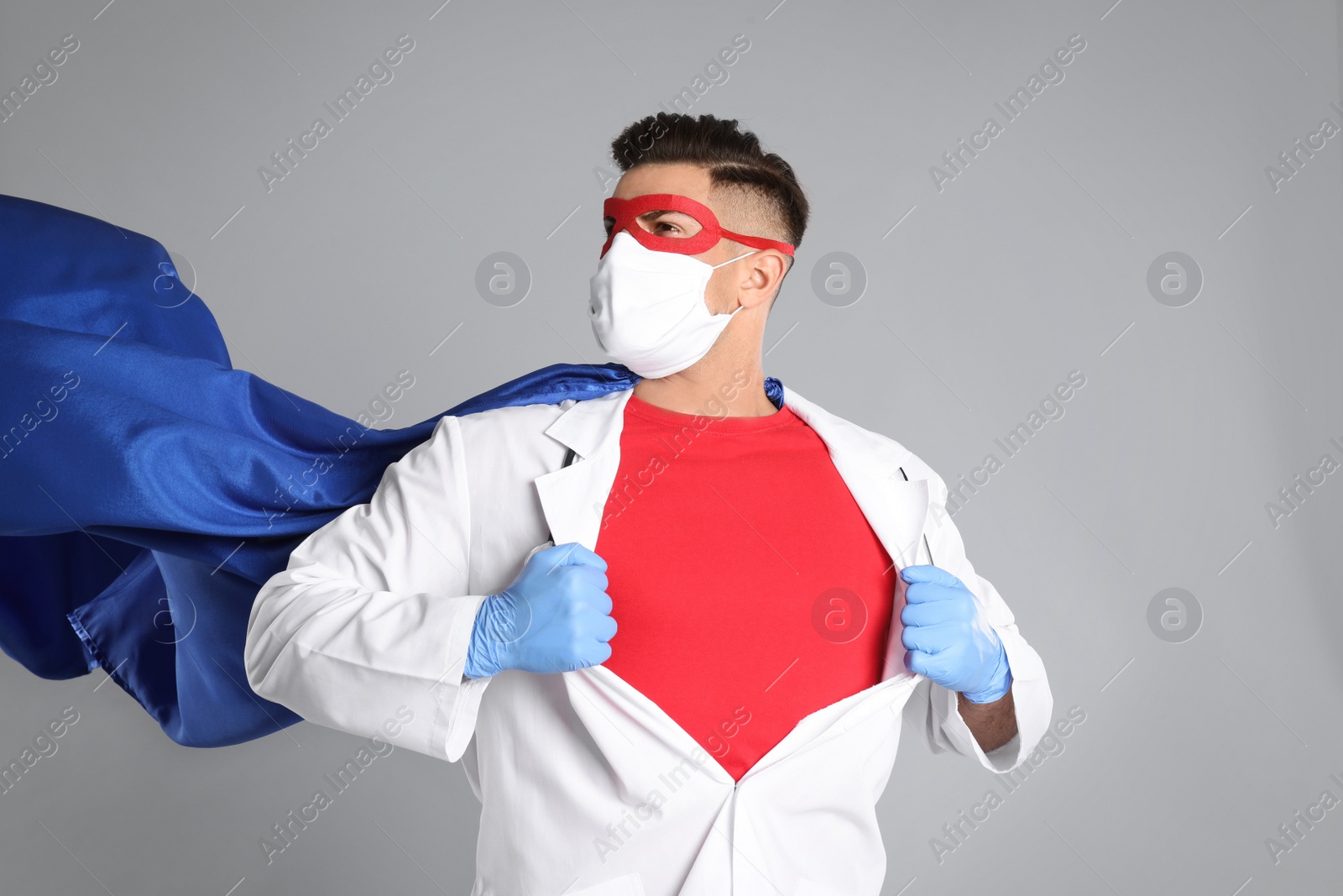 Photo of Doctor wearing face mask and cape on grey background. Super hero power for medicine