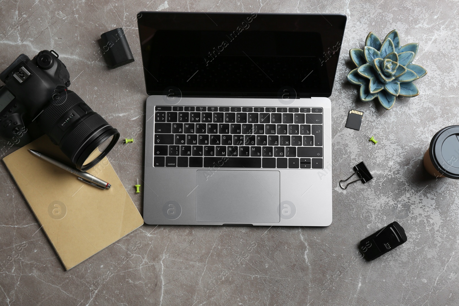 Photo of Photographer's workplace with laptop and camera on table, top view