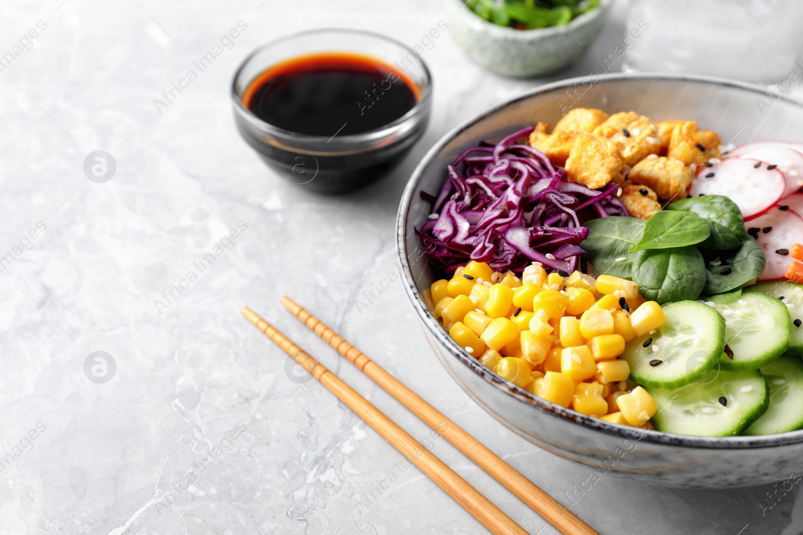 Photo of Delicious salad with chicken, vegetables and spinach on grey marble table, closeup. Space for text