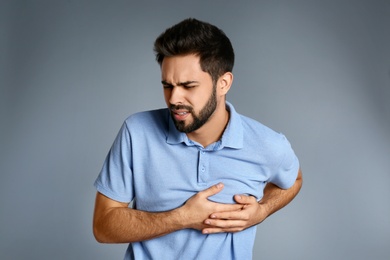 Photo of Man suffering from heart pain on grey background