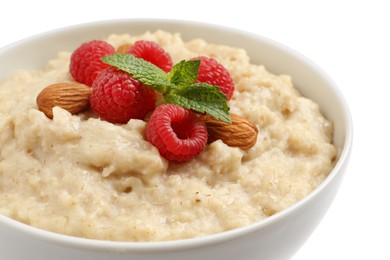 Photo of Tasty oatmeal porridge with raspberries and almond nuts in bowl on white background, closeup