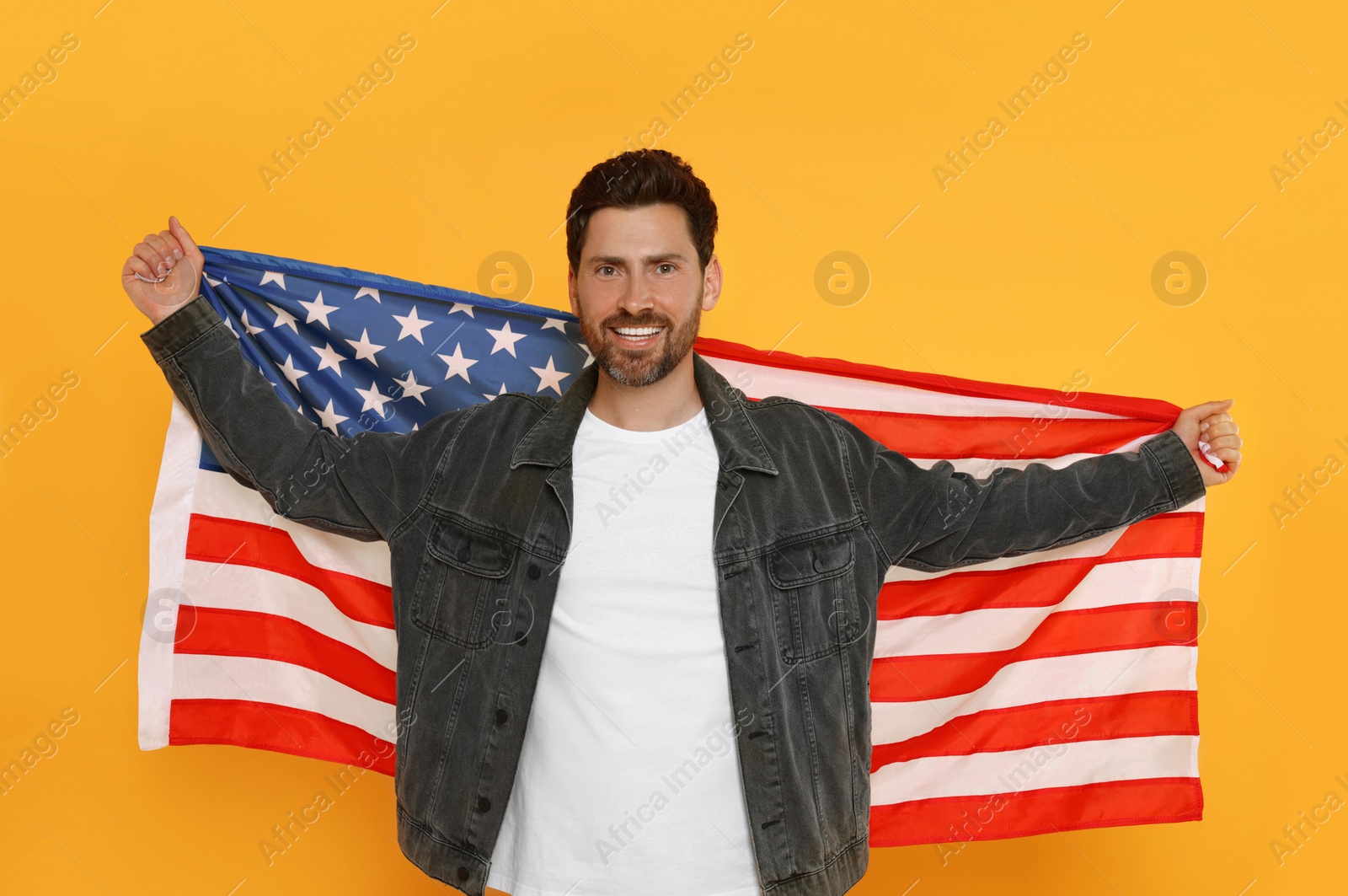 Photo of 4th of July - Independence Day of USA. Happy man with American flag on yellow background