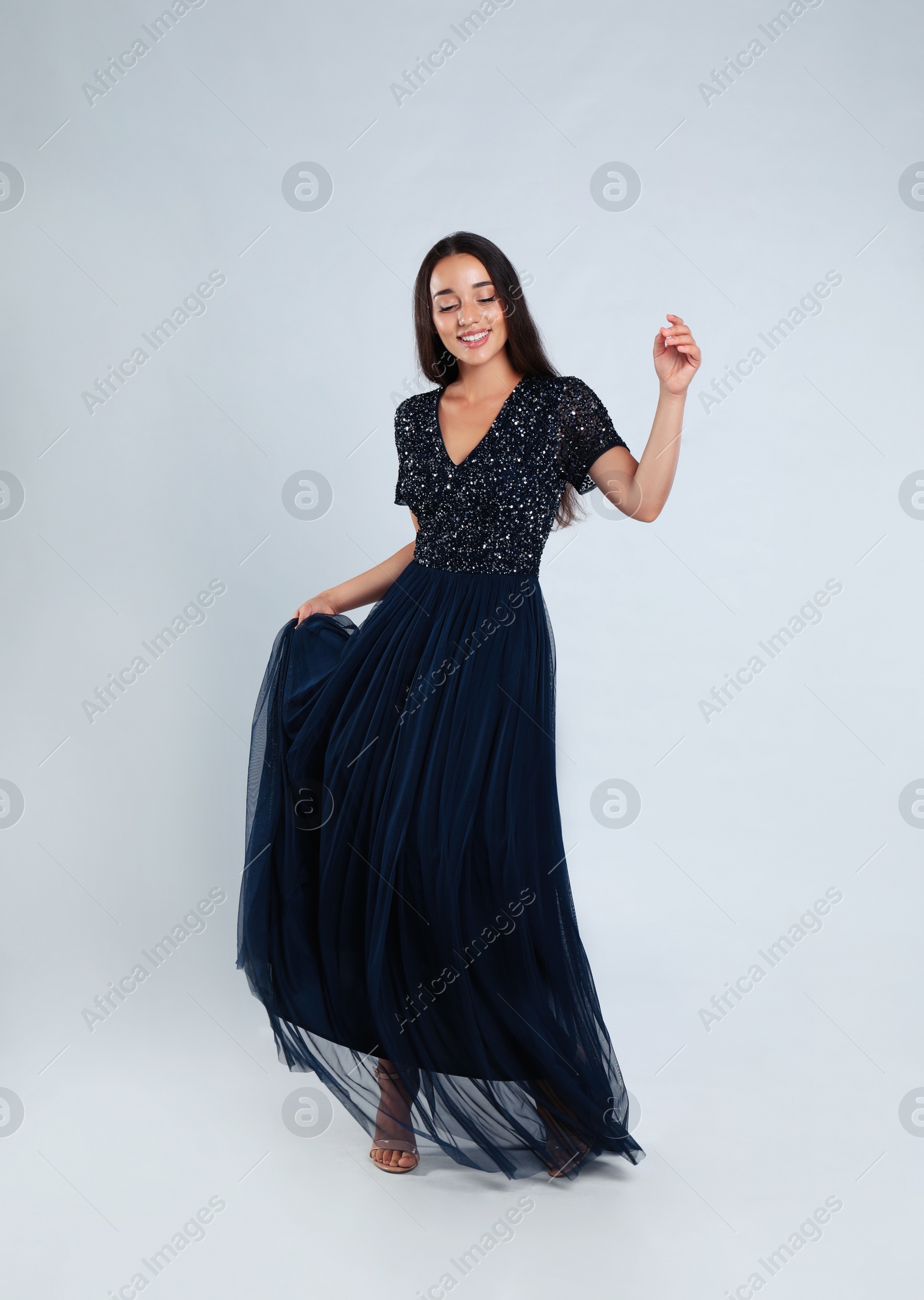 Photo of Young woman wearing stylish dress on light grey background