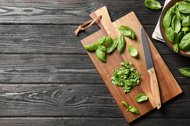 Photo of Fresh green basil on black wooden table, flat lay. Space for text