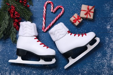 Flat lay composition with pair of ice skates and Christmas decor on blue wooden table