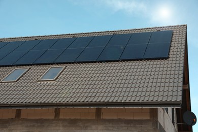 Photo of House with installed solar panels on roof. Alternative energy