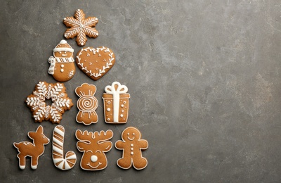 Photo of Christmas tree shape made of delicious gingerbread cookies on grey table, flat lay. Space for text