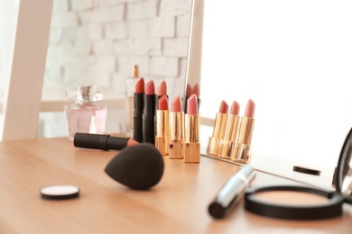 Photo of Cosmetics on dressing table in makeup room, closeup