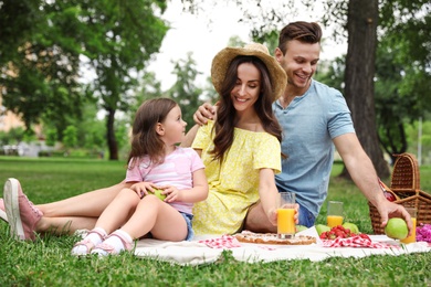 Photo of Happy family having picnic in park on summer day