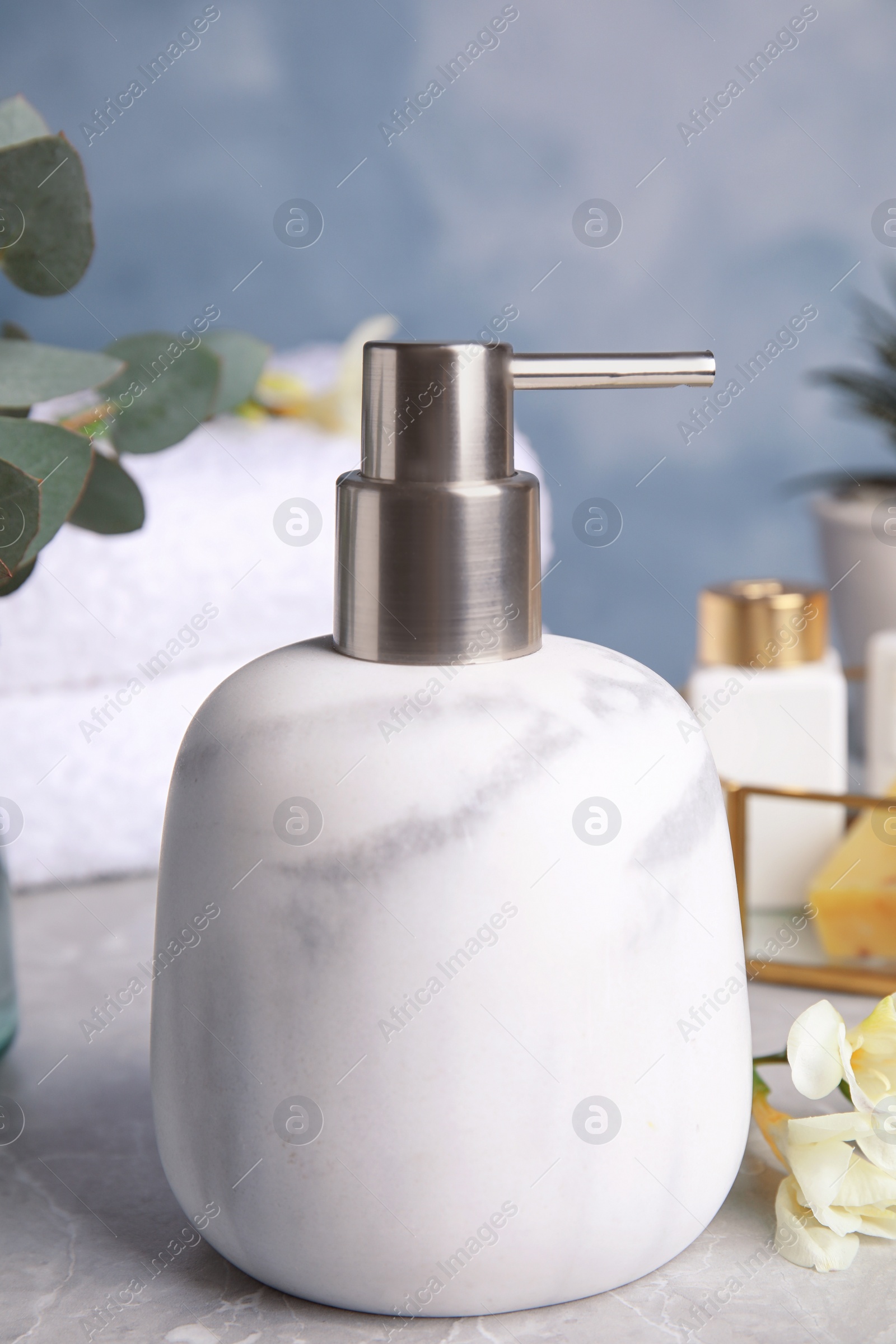 Photo of Modern soap dispenser on grey marble table