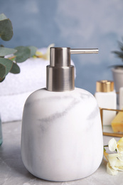 Modern soap dispenser on grey marble table