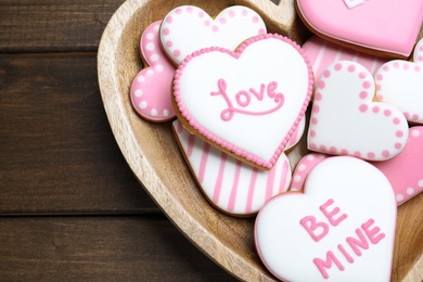 Photo of Delicious heart shaped cookies in bowl on wooden table, top view. Valentine's Day