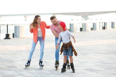 Happy family roller skating on city street