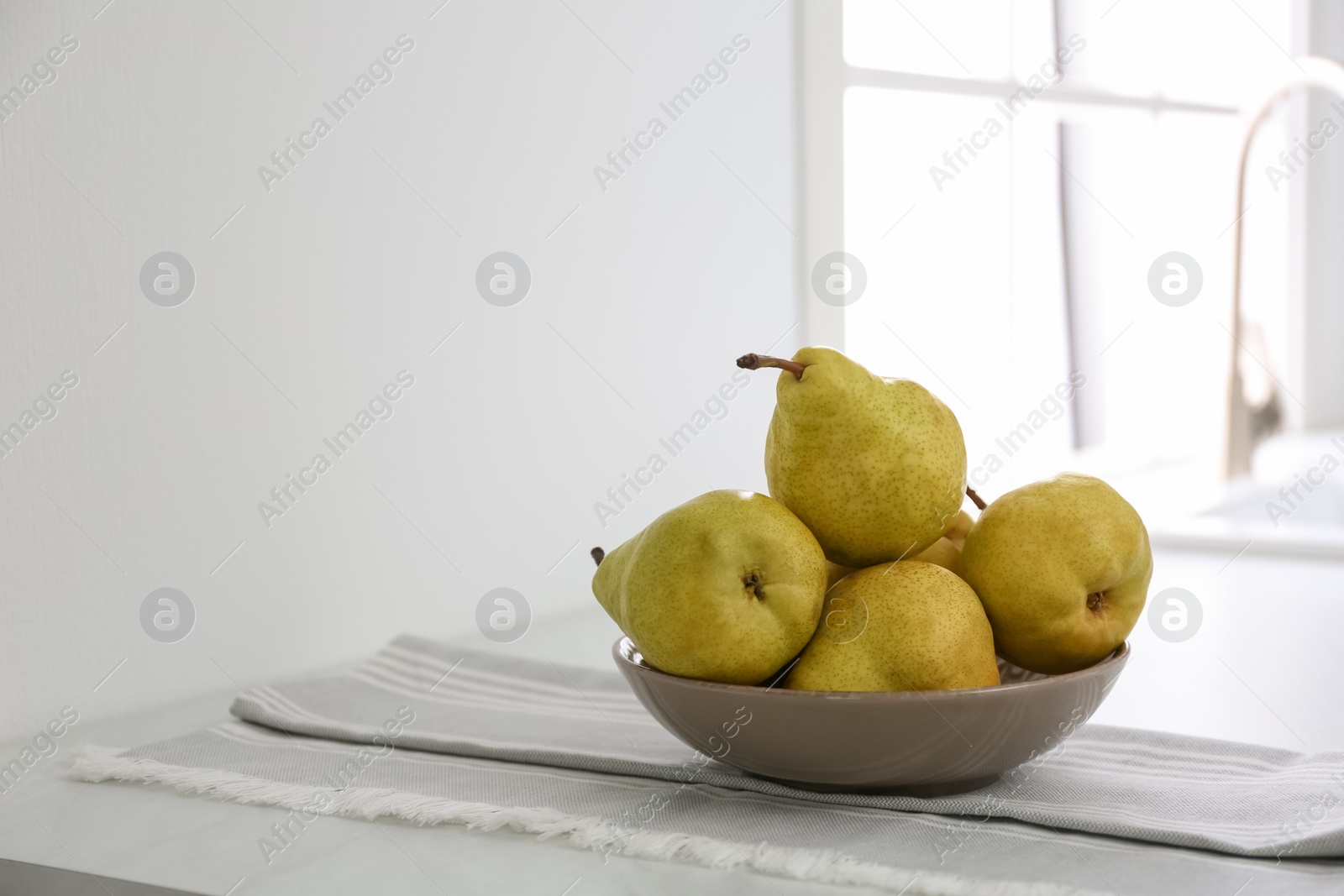 Photo of Fresh ripe pears on countertop in kitchen