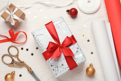 Flat lay composition with beautiful Christmas gift boxes and wrapping paper on white wooden table