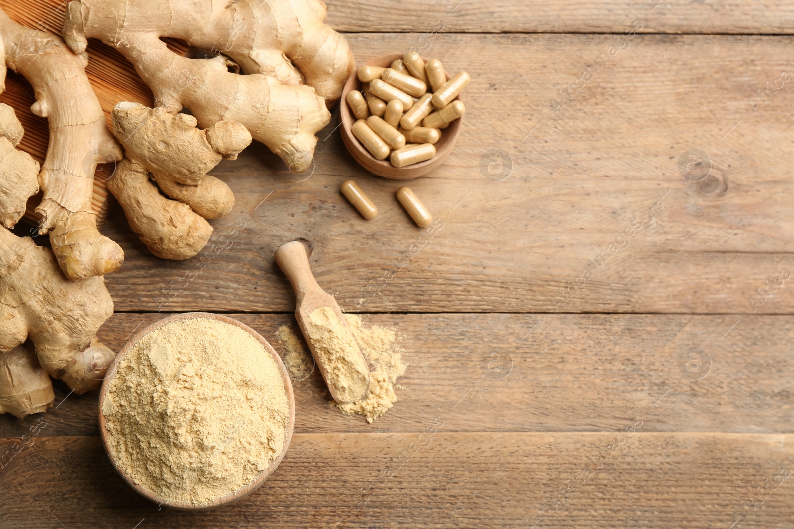 Photo of Dry, fresh and capsuled ginger on wooden table, flat lay. Space for text