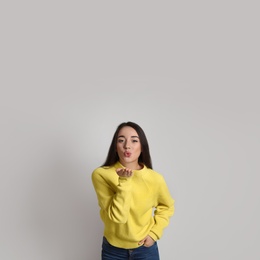 Beautiful young woman wearing yellow warm sweater on white background. Space for text