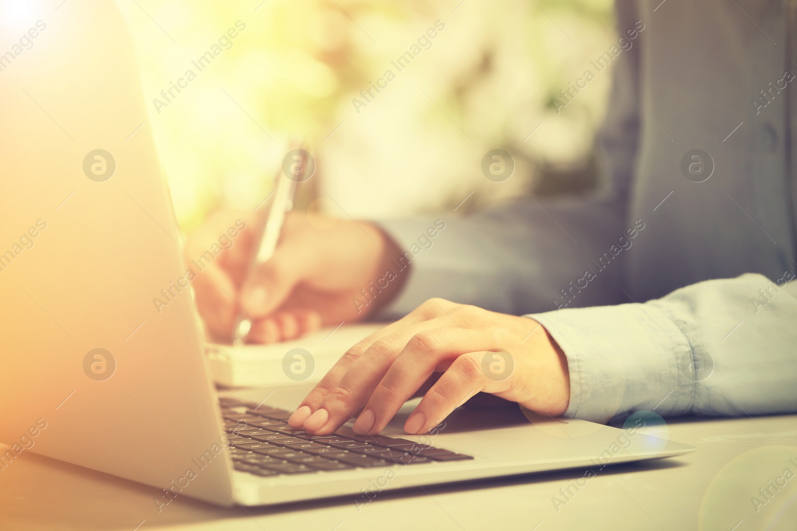 Image of Woman working with laptop at table indoors, closeup