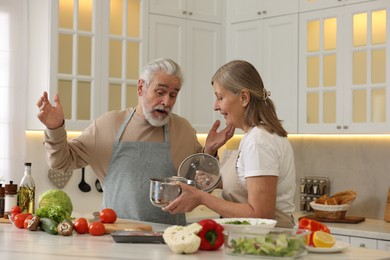 Photo of Lovely senior couple cooking together in kitchen