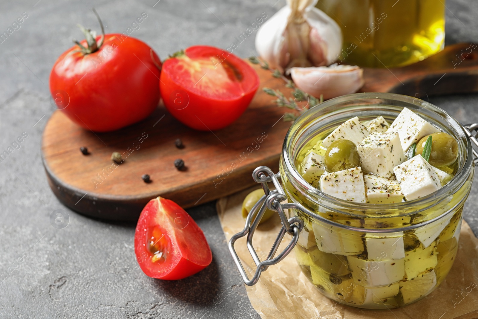 Photo of Composition with pickled feta cheese in jar on grey table