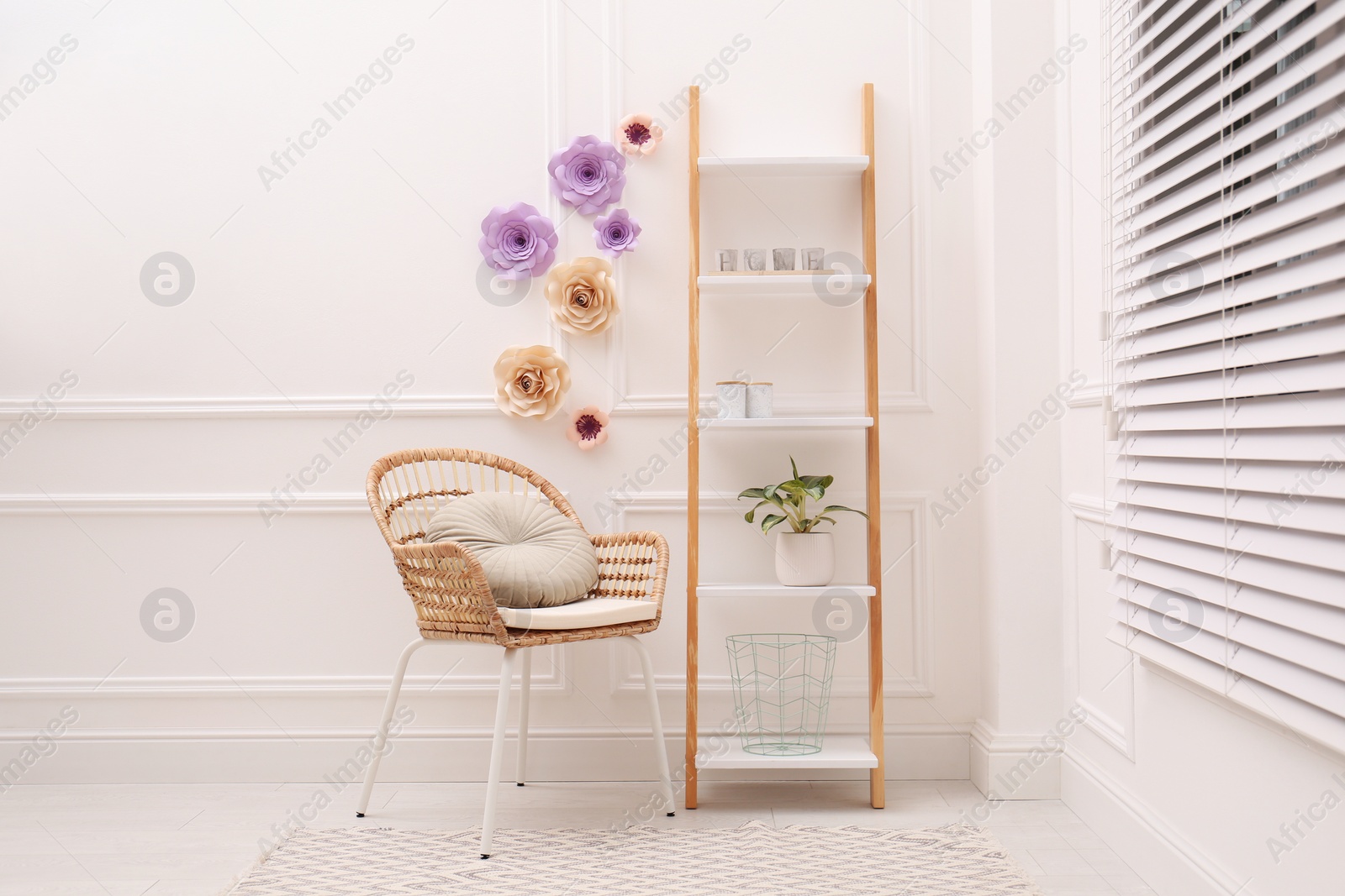 Photo of Stylish room interior with floral decor and wicker armchair