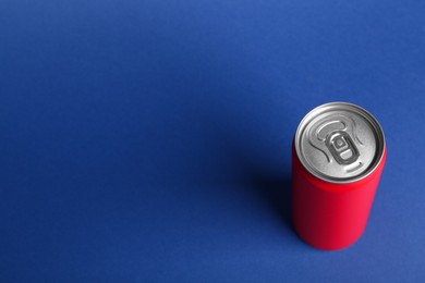 Energy drink in red can on blue background, above view. Space for text