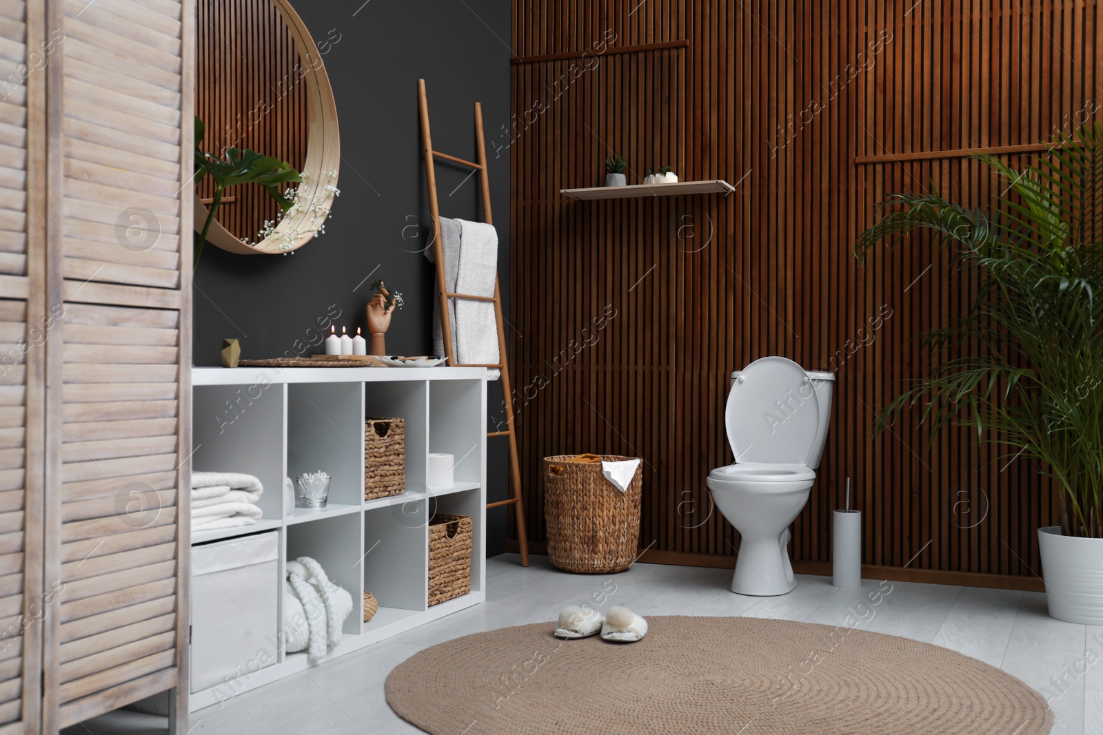 Photo of Elegant modern bathroom with toilet bowl near wooden wall