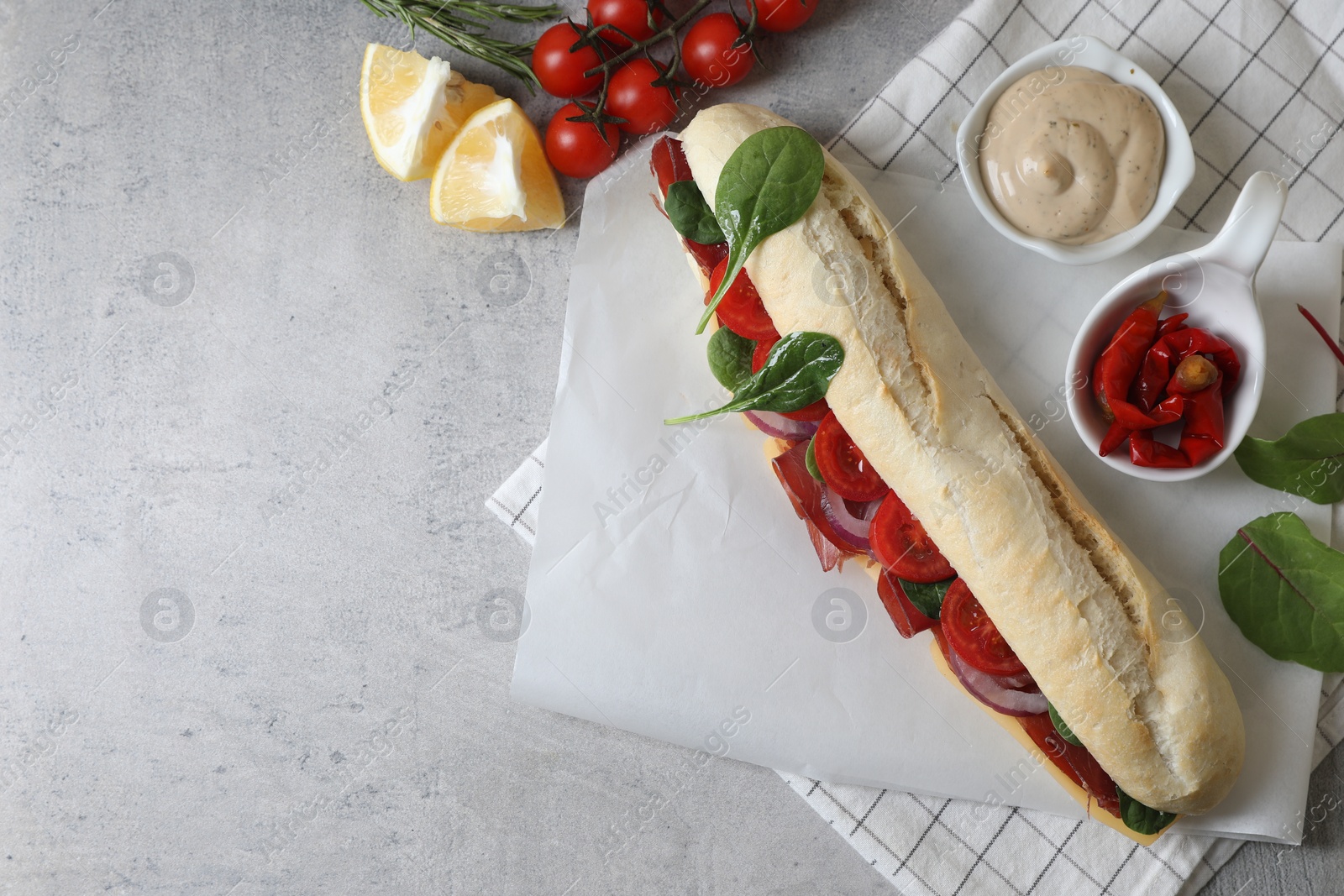 Photo of Delicious sandwich with bresaola served on light table, flat lay. Space for text