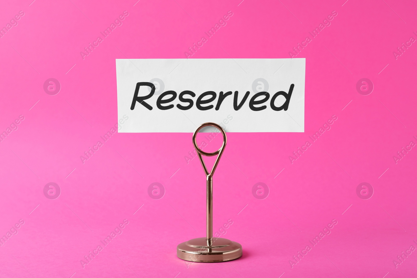 Photo of Elegant sign Reserved on pink background. Table setting element