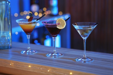 Photo of Different martini cocktails on table in bar