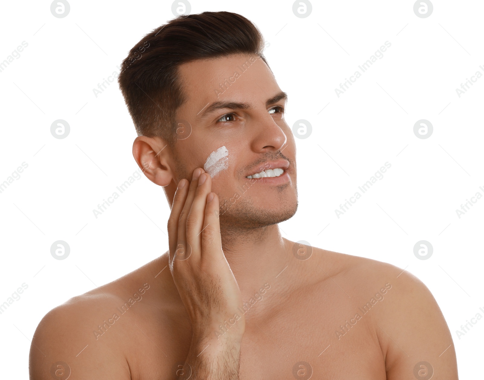 Photo of Handsome man applying face cream on white background