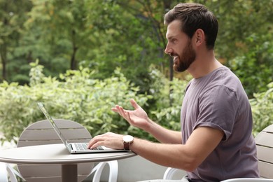 Photo of Handsome man with laptop in outdoor cafe