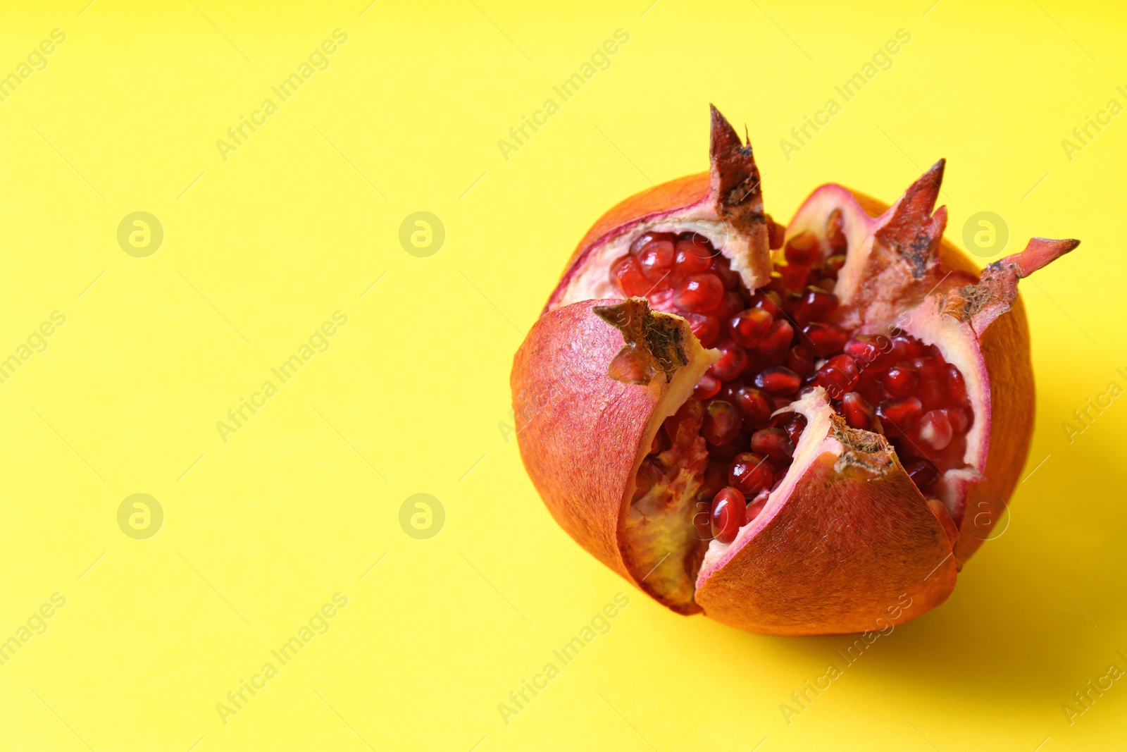 Photo of Ripe pomegranate on color background, space for text