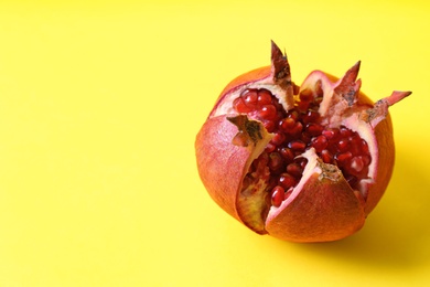 Photo of Ripe pomegranate on color background, space for text