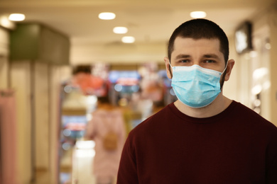 Photo of Man wearing disposable mask indoors. Dangerous virus