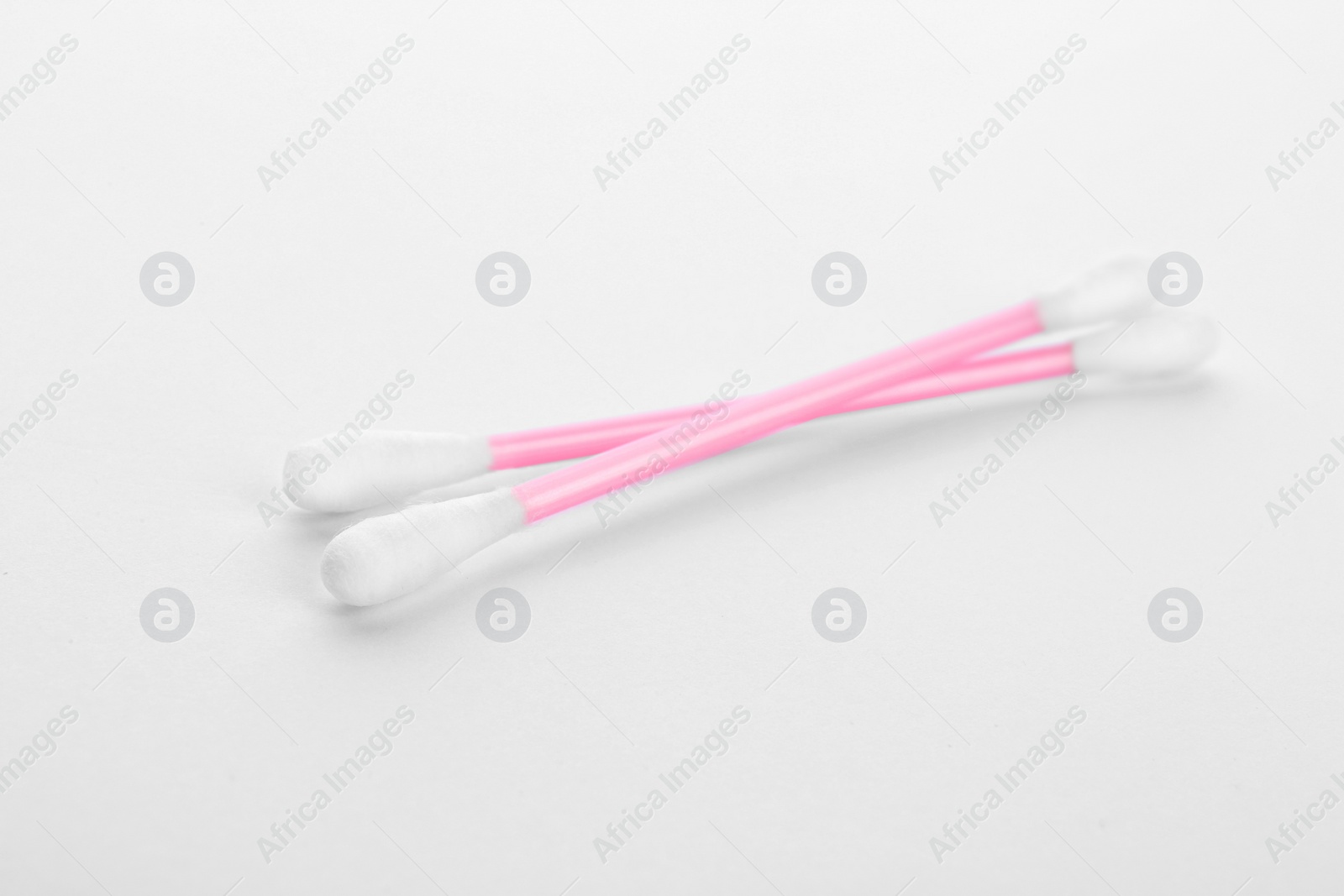 Photo of Pink plastic cotton swabs on white background