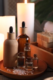 Photo of Spa composition. Bottles of cosmetic products and sea salt on wooden table