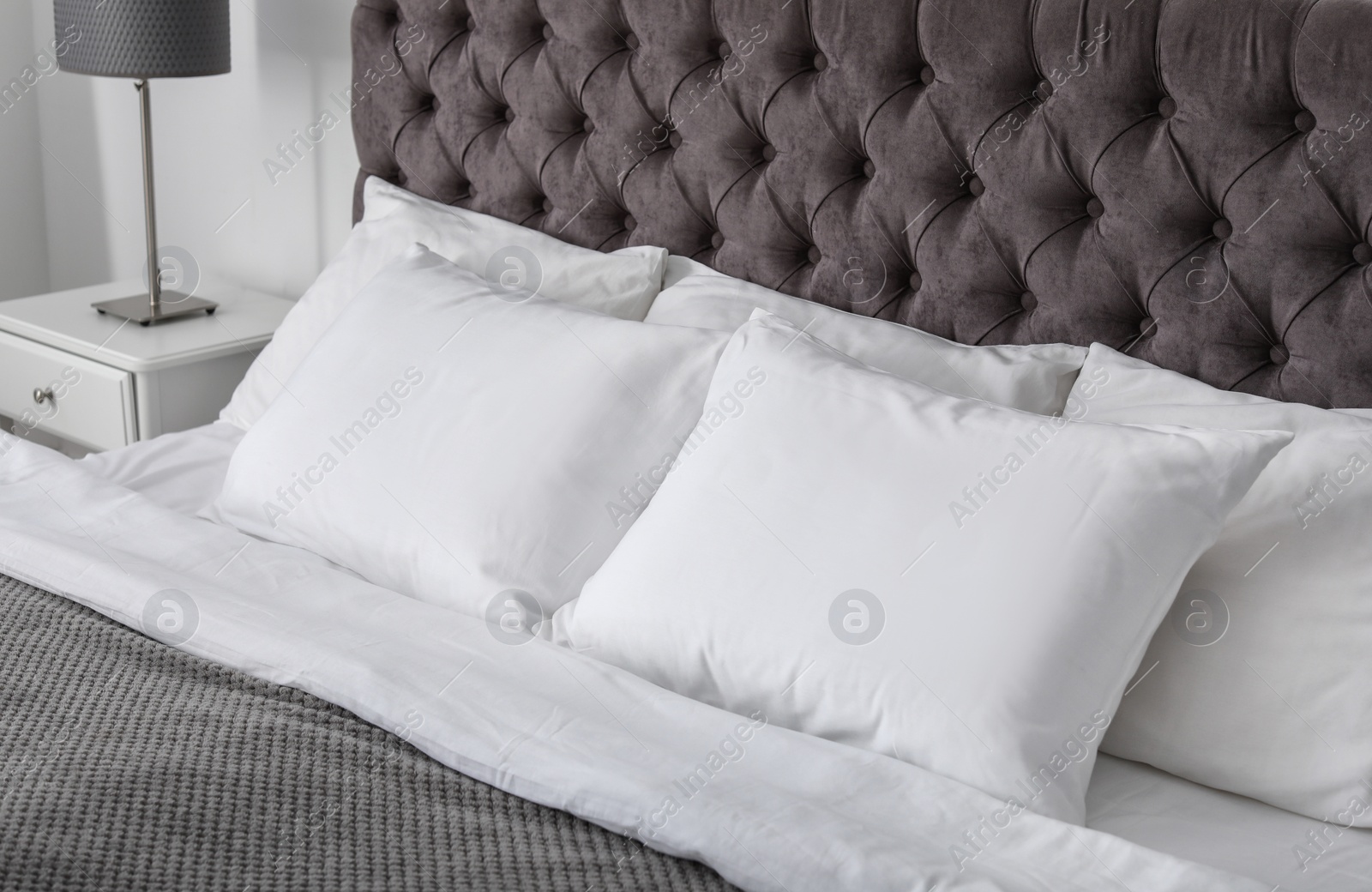 Photo of Soft white pillows on comfortable bed indoors