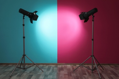 Photo of Professional lighting equipment near wall in photo studio. Space for text